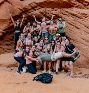 Group of women holding up man in zion national park