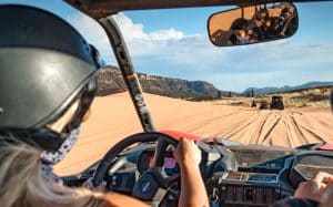 women driving utv in coral pink sand dunes state park