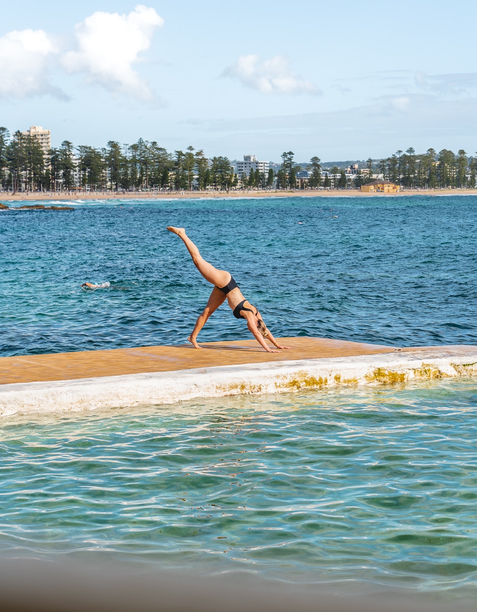 woman doing yoga near the water in manly beach sydney australia