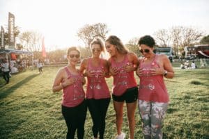 four women in pink holding their boobs for breast cancer awareness