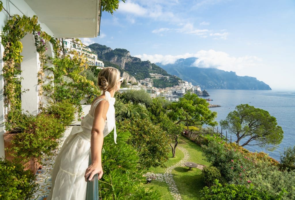 woman looking over balcony to the sea in the amalfi coast